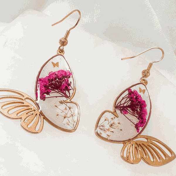 Rose gold Garden Wing Earrings with deep pink and white pressed flower butterfly wings encased in resin, lightweight and hypoallergenic