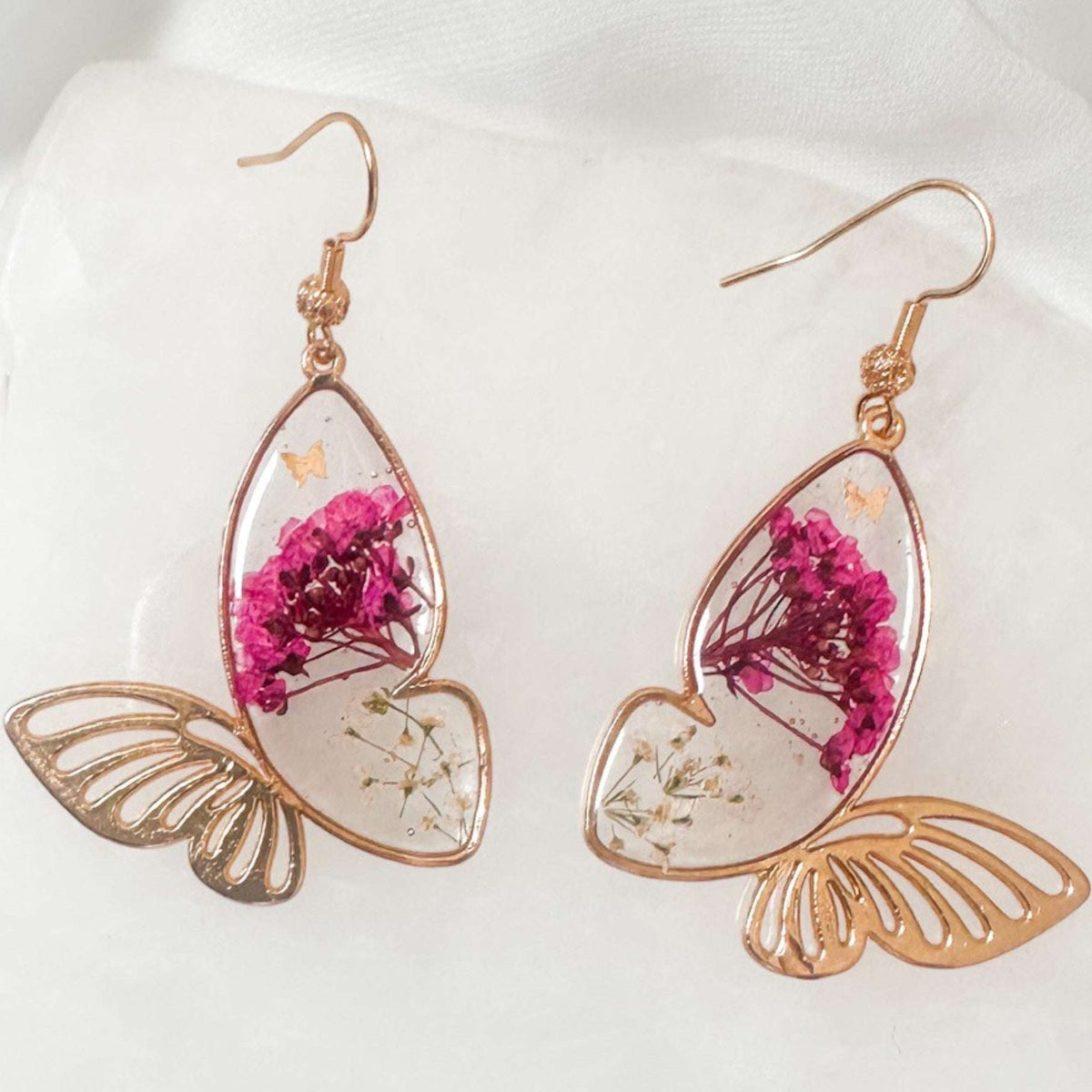 Rose gold Garden Wing Earrings with pressed pink and white flowers in butterfly resin wings and delicate gold accents