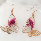 Rose gold Garden Wing Earrings with pressed pink and white flowers in butterfly resin wings and delicate gold accents