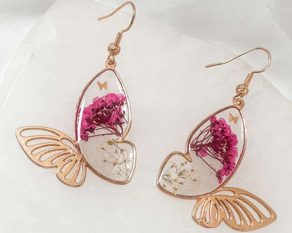 Garden Butterfly Wing Earrings with pressed deep pink and white flowers encased in resin butterfly wings and gold butterfly accents.