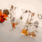 Pressed flower resin decor spelling LOVE with real pressed wildflowers and tiny ladybug in clear resin letters