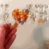 Pressed flower resin decor spelling LOVE with real wildflowers and a tiny ladybug inside clear resin letters