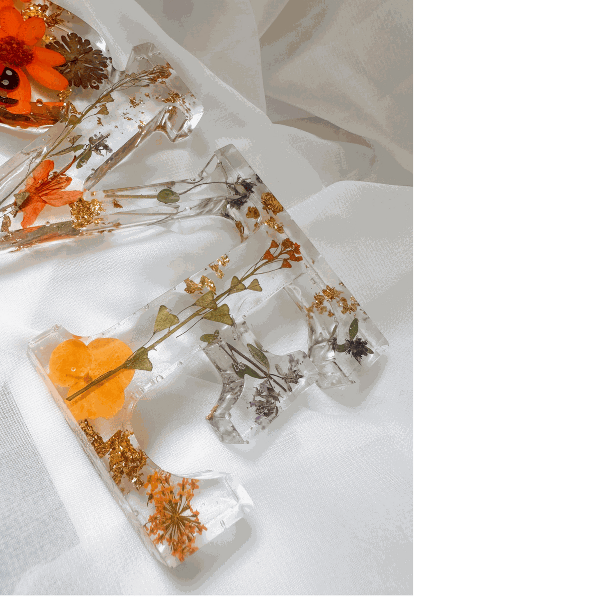 Pressed flower resin decor spelling LOVE with real wildflowers and a tiny ladybug inside clear resin letters