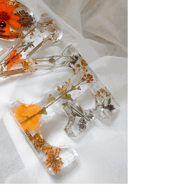 Pressed flower resin decor spelling LOVE with real wildflowers and a tiny ladybug inside clear resin letters