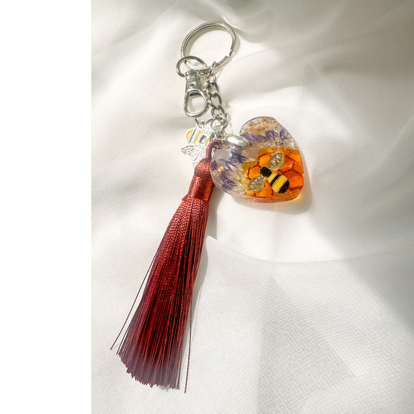 Honeybee Heart Bag Charm with rhinestone bee, pressed purple flowers, golden honeycomb in resin heart and copper tassel keychain