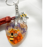Honeybee Heart Bag Charm with rhinestone bee, golden honeycomb, pressed purple flowers, enamel bee charm, and copper tassel on silver keychain ring