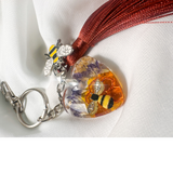 Honeybee Heart Bag Charm with rhinestone bee, pressed purple flowers, enamel bee charm, and copper tassel in heart-shaped resin keychain