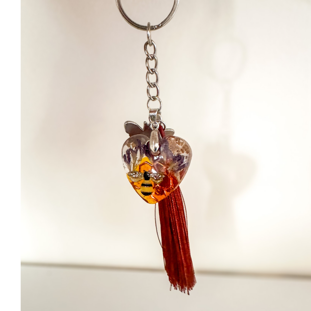 Honeybee Heart Bag Charm with rhinestone bee, pressed purple flowers, enamel bee charm, and copper tassel in clear resin heart keychain