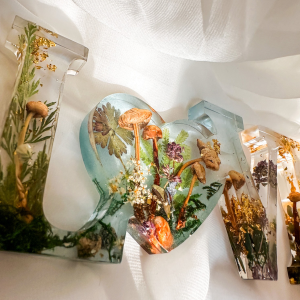 Boreal Mushroom LOVE word art with real hand-foraged mushrooms, ferns, moss, and gold leaf accents in clear resin letters