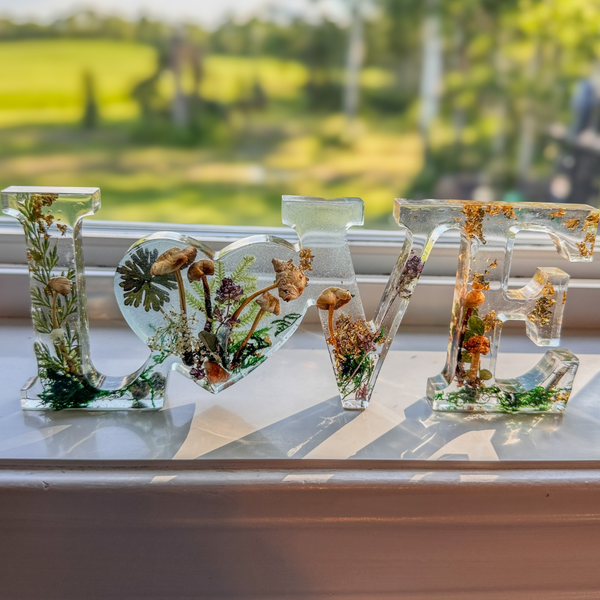 Boreal Mushroom LOVE resin decor with hand-foraged mushrooms, ferns, moss, and gold leaf accents in clear letters
