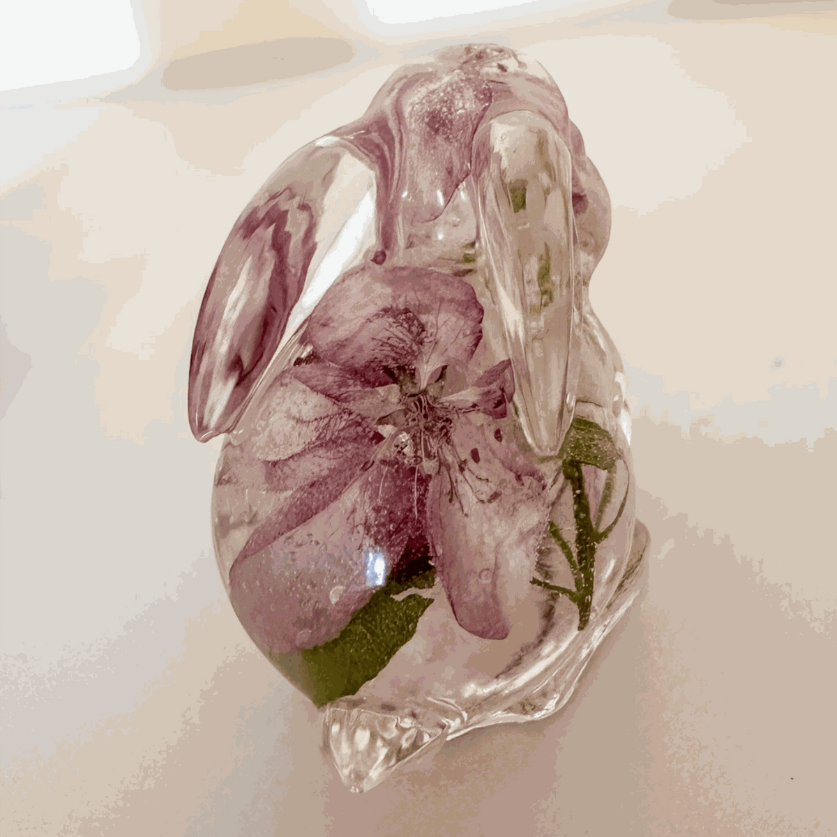 Pair of handmade apple blossom bunnies filled with preserved apple blossoms in clear resin decor