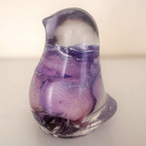 Purple rose preserved inside clear resin bird decor with lavender hues