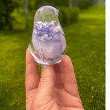 Purple rose preserved inside clear resin bird sculpture with lavender and violet tones