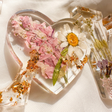Daisy resin word art with pressed white daisy, blush blooms, gold leaf flakes, and heart-shaped O design