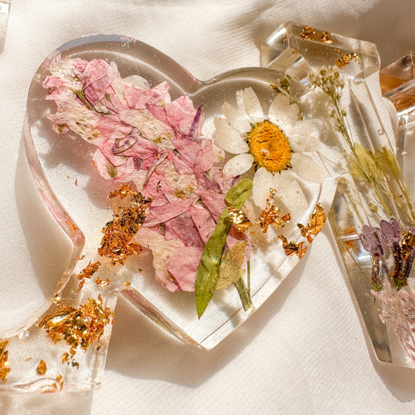 Daisy resin word art with pressed white daisy, blush blooms, gold leaf flakes, and heart-shaped O design