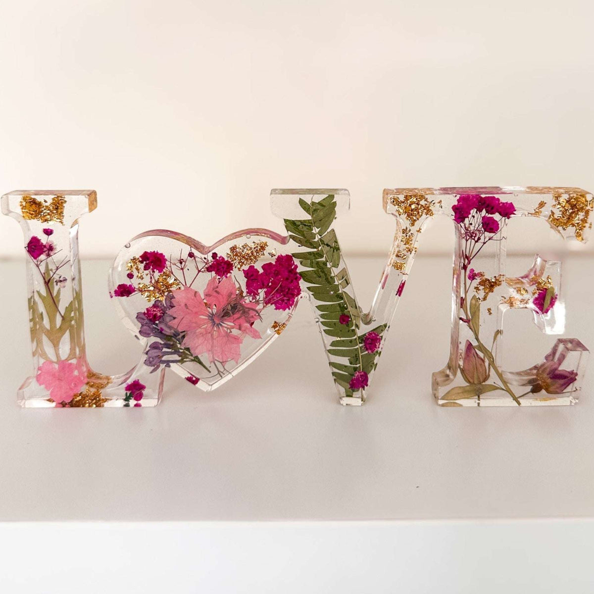 Fuchsia Garden LOVE resin word art with pink and fuchsia pressed flowers, fern fronds, and gold leaf flakes
