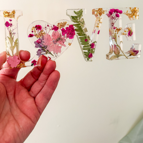 Fuchsia Garden LOVE resin word art with pressed pink and fuchsia flowers, fern fronds, and gold leaf flakes