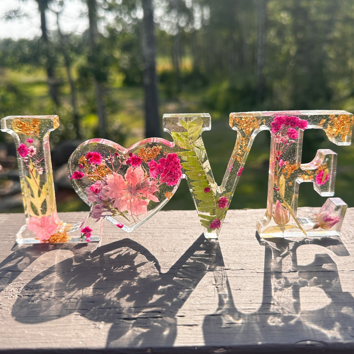 Fuchsia Garden LOVE resin word art with pink and fuchsia flowers, fern fronds, and gold leaf flakes