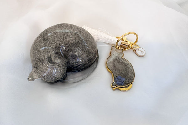 Cat-shaped keychain and figurine on a white surface