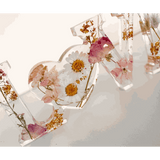Whispering Meadow LOVE resin word art with white daisies, pink and purple wildflowers, bunny tail accent, and gold leaf flakes
