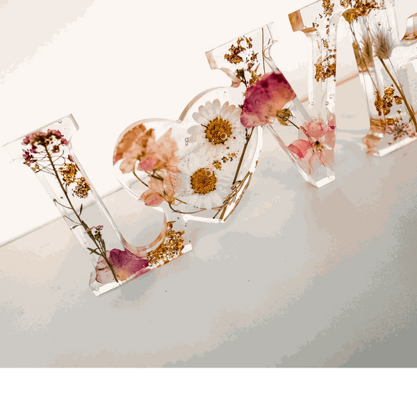 Whispering Meadow LOVE resin word art with white daisies, pink and purple wildflowers, bunny tail, and gold leaf flakes