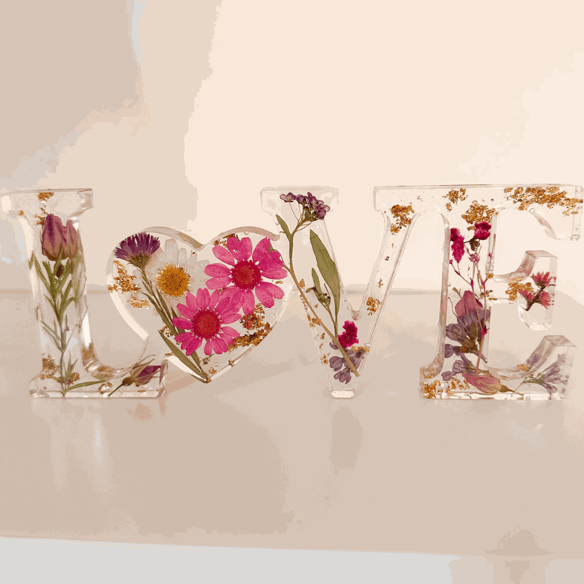 Wildflower resin word art LOVE with pink daisies, purple wildflowers, rose buds, and gold leaf flakes