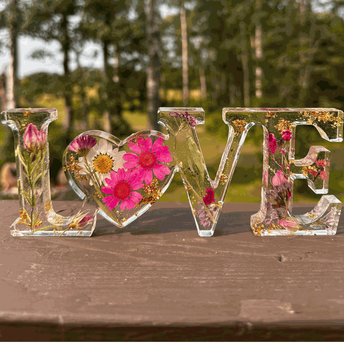Wildflower meadow LOVE word art with pink daisies, purple wildflowers, rose buds, and gold leaf in clear resin letters