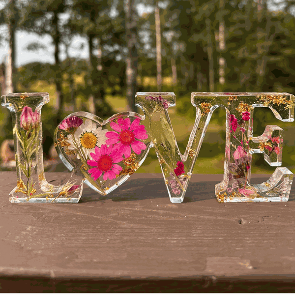 Wildflower meadow LOVE word art with pink daisies, purple wildflowers, rose buds, and gold leaf in clear resin letters