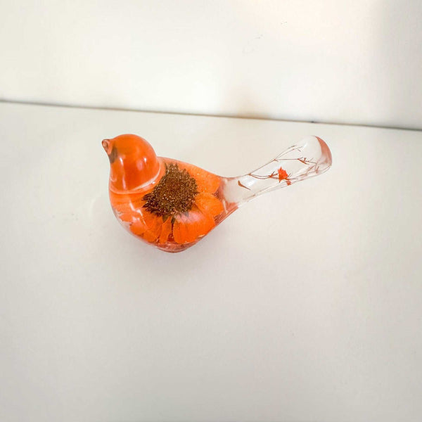 Orange sunflower resin bird decor with a bright orange flower body and clear tail featuring small floral accents and copper leaf base.