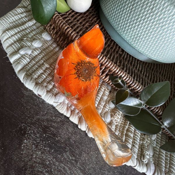 Orange sunflower resin bird decor with bright orange petals, a detailed flower center, clear resin tail, and copper leaf base accents.