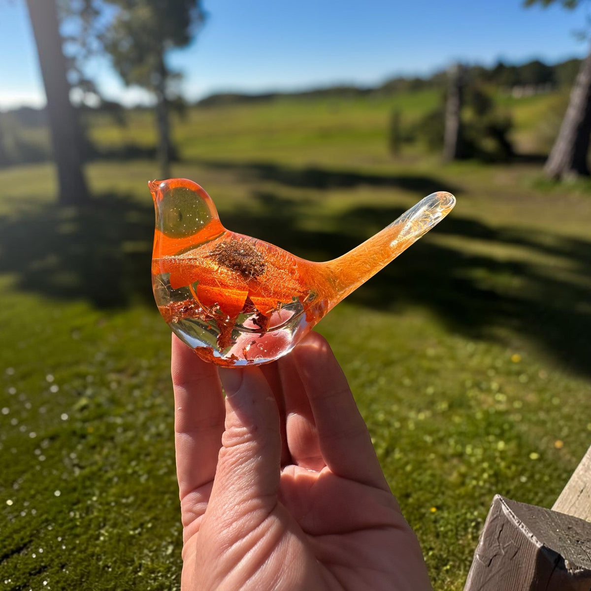 Orange sunflower resin bird decor with clear body, bright orange flower petals, and copper leaf accents at the base.