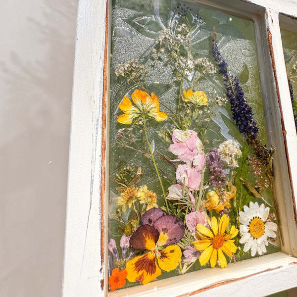 Pressed Flower Window Frame wall art with real dried yellow, purple, white, and orange wildflowers set in clear resin within a distressed white wood frame
