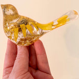 Sunflower resin bird decor with clear hand-poured resin, real dried yellow sunflower petals, and gold leaf accents inside a small bird shape.