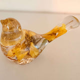 Sunflower resin bird decor in clear resin with preserved yellow sunflower petals and gold leaf accents inside a small bird shape.