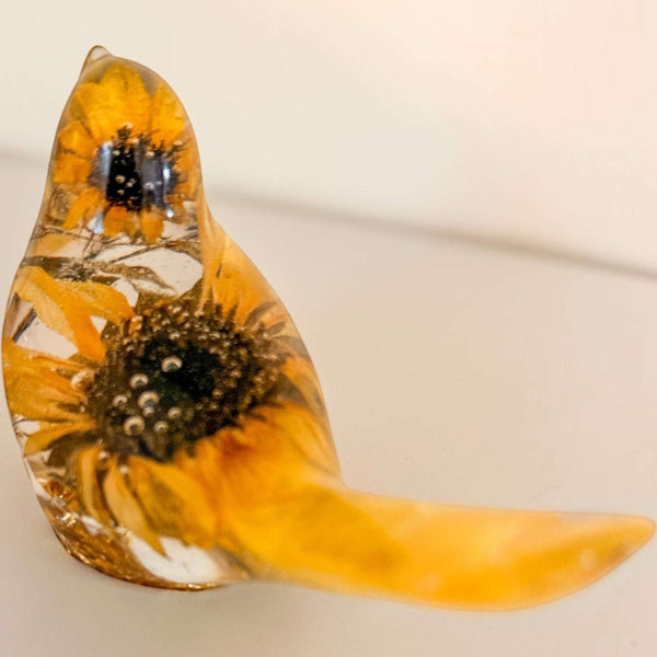 Sunflower resin bird decor featuring real dried sunflower petals and flowers encased in clear glossy resin with gold accents.
