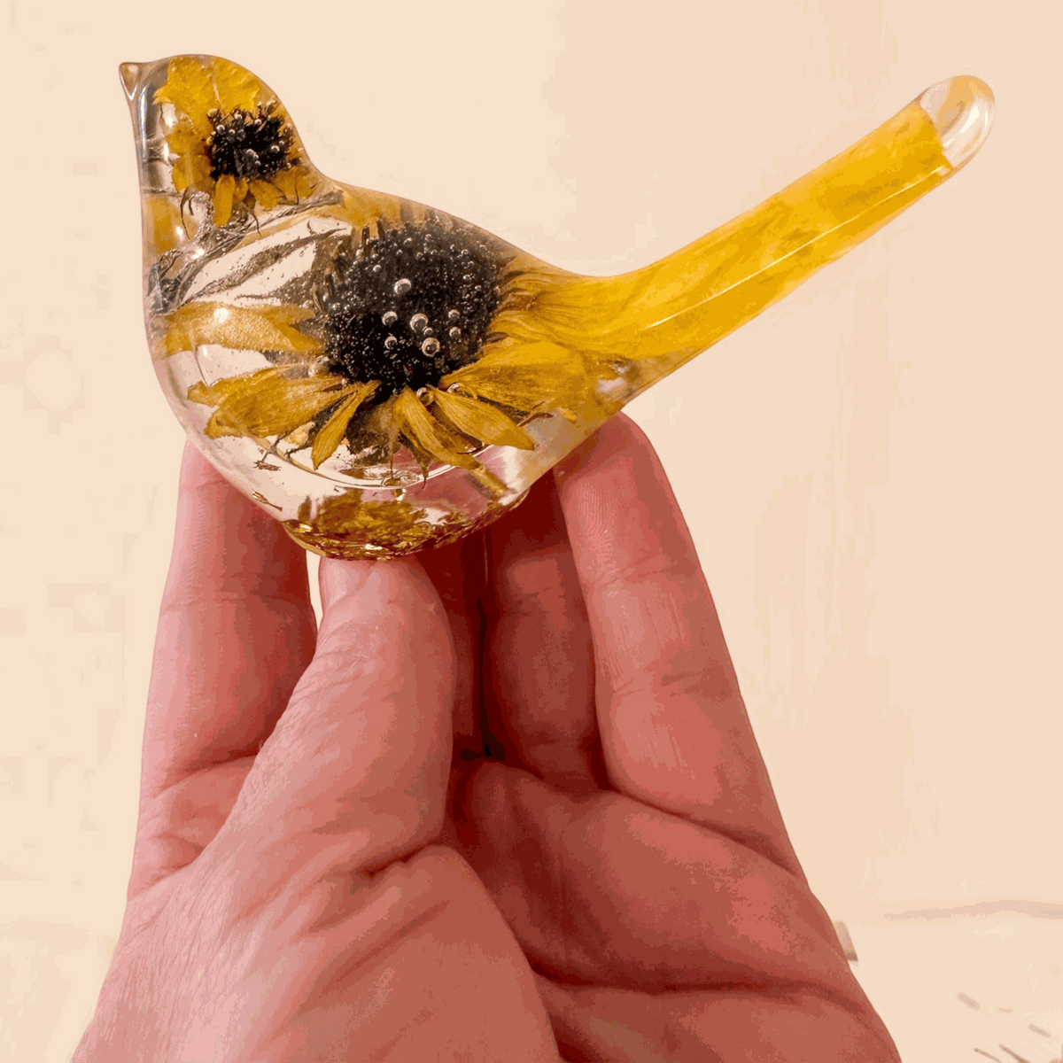 Sunflower resin bird decor with clear hand-poured resin, real dried sunflower blooms, and yellow-tinted tail accents.