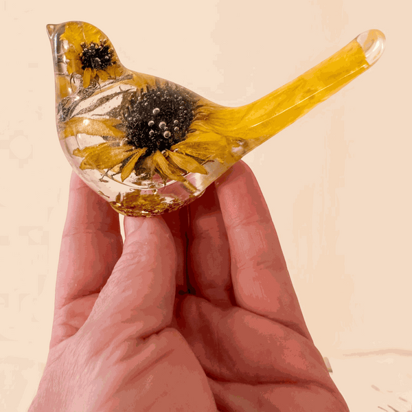 Sunflower resin bird decor with clear hand-poured resin, real dried sunflower blooms, and yellow-tinted tail accents.