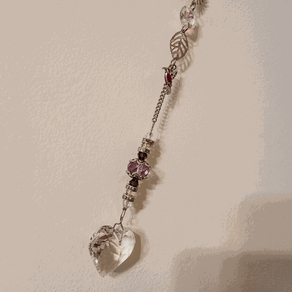Pressed rose suncatcher featuring a clear resin heart with silver leaf, crimson pressed roses, and faceted crystal prisms on a silver chain.