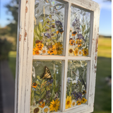 Pressed Flower Window Frame with white distressed wood and four resin-filled panes featuring real dried orange, yellow, purple, and white wildflowers with butterfly and dragonflies set on holographic backing.