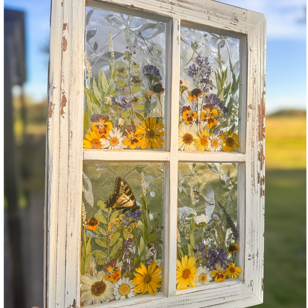 Pressed Flower Window Frame with white distressed wood, clear resin panes containing real dried yellow, white, and purple wildflowers, butterflies, and intricate holographic patterns behind each pane.