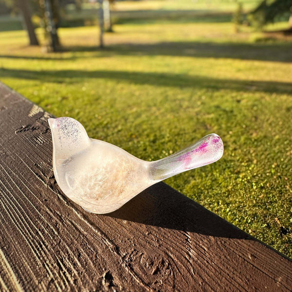 Glow in the Dark Resin Bird, translucent milky white with violet glitter and a rounded beak-shaped tail.