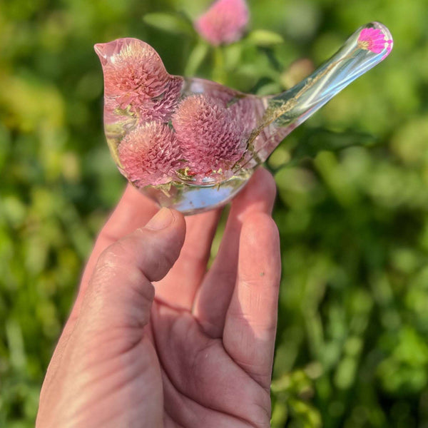 Dried flower resin bird with pink and lilac clover blossoms, clear resin body and delicate floral tail detail