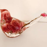 Dried flower resin bird with a clear body, rosy pink clover blossoms, and delicate stems forming the tail