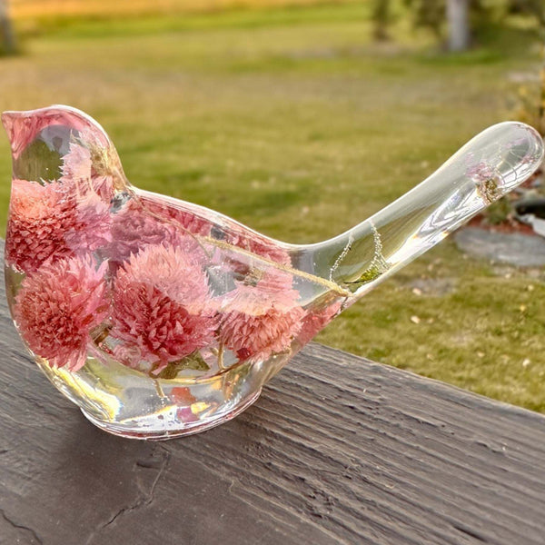 Dried flower resin bird with clear glass-like body, rosy pink clover blossoms, and delicate stems in the tail