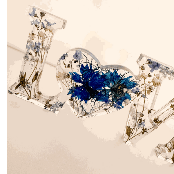 Forget me not resin love sign in clear resin, featuring blue pressed flowers, greenery and a heart-shaped O