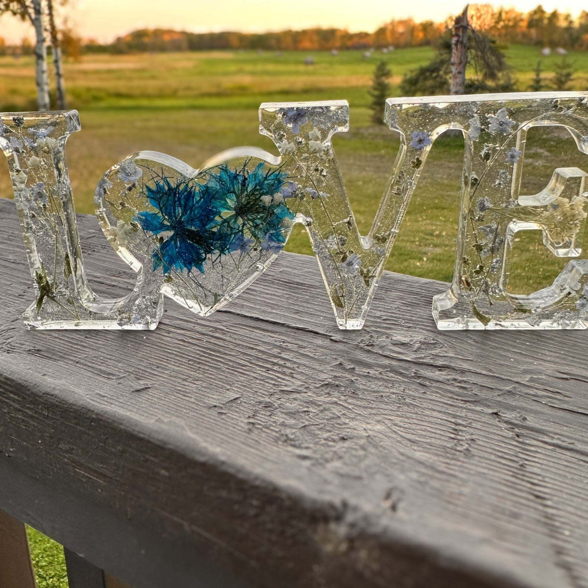 forget me not resin love sign in clear resin with blue pressed flowers, silver leaf flakes and heart-shaped O