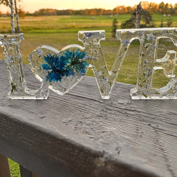 forget me not resin love sign in clear resin with blue pressed flowers, silver leaf flakes and heart-shaped O