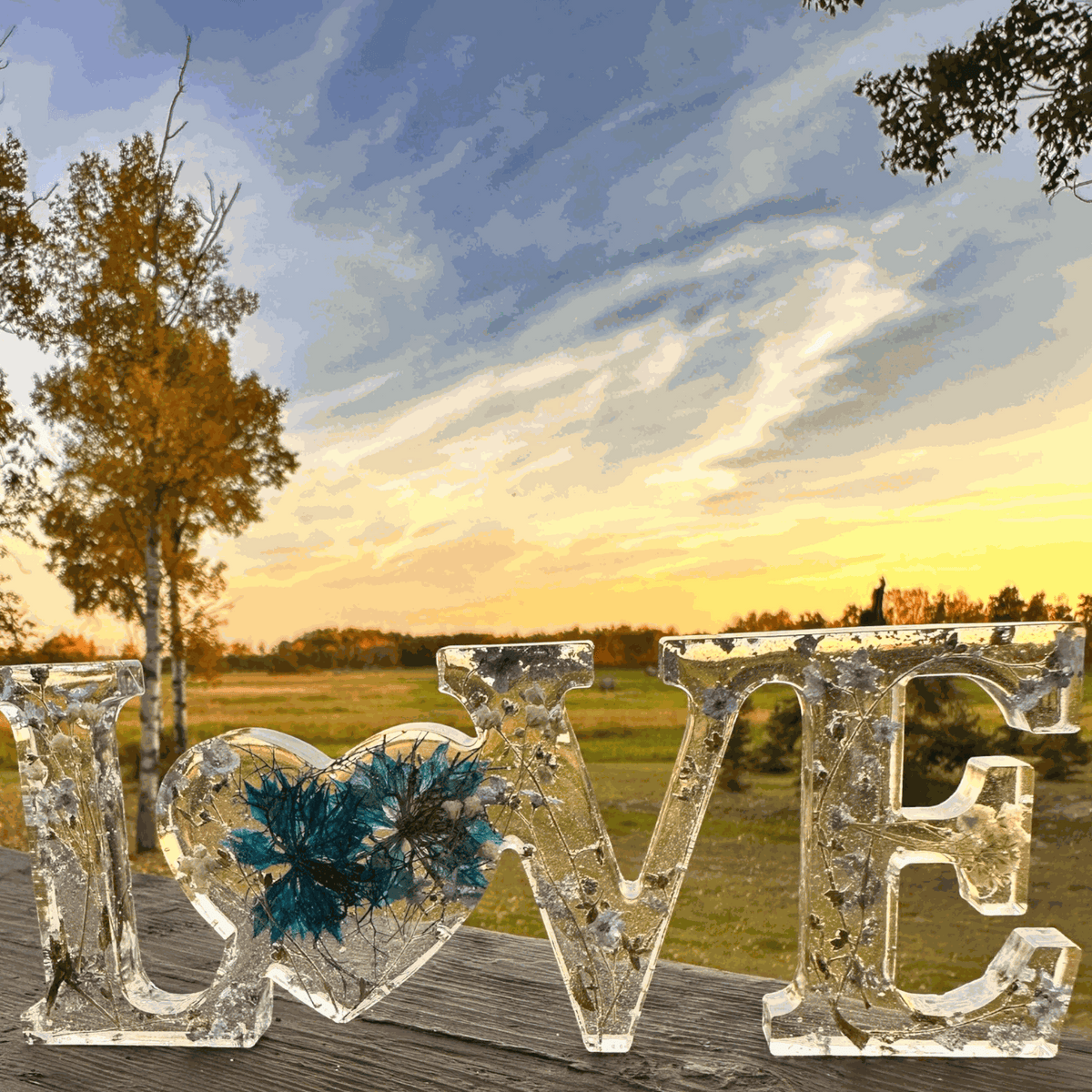 forget me not resin love sign in clear resin with blue flowers, silver leaf, and heart-shaped O centerpiece