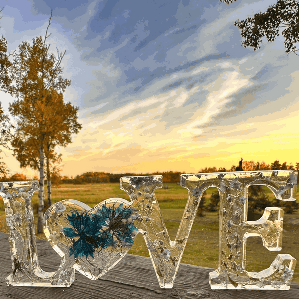 forget me not resin love sign in clear resin with blue flowers, silver leaf, and heart-shaped O centerpiece