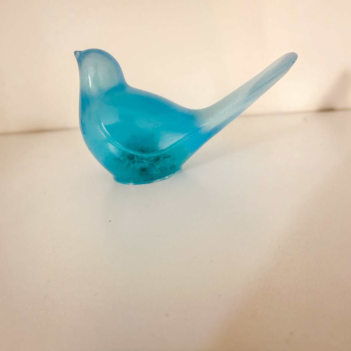 Teal glow resin bird decor, translucent turquoise resin songbird with an elongated tail and curved beak